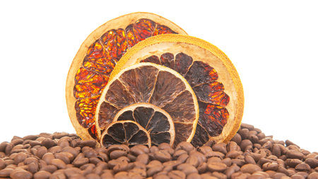 Detailed shot of dried citrus slices with vibrant hues, surrounded by aromatic coffee beans. Isolated on white, great for gourmet food, beverage, or home decor concepts.の写真素材