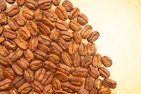 Oval pile of roasted coffee beans on a gold reflective background, revealing their warm tones and natural texture. Perfect for coffee culture visuals.の写真素材