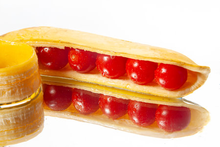 Surreal food composition of a peeled banana filled with glossy cherry tomatoes, reflecting on a...