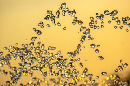 silhouettes of drops falling water fountain against the backdrop of the setting sunの写真素材