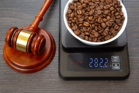 A wooden gavel with a gold band beside a digital scale displaying 282.2g, holding a bowl of roasted...