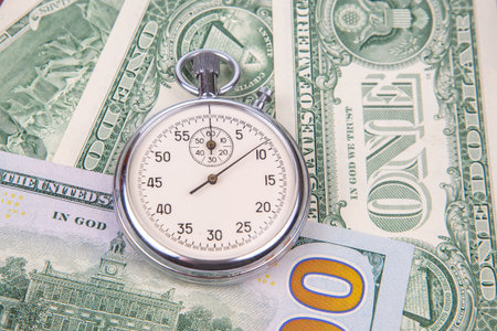 mechanical stopwatch on the background of dollars. Part time accuracy for business. business and finance time.の写真素材