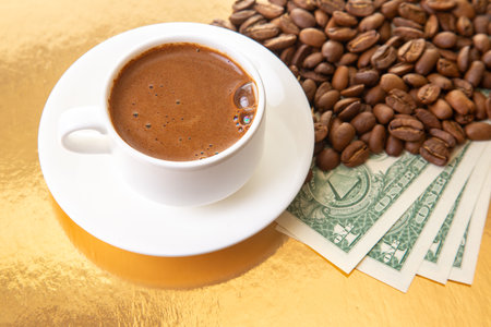 close-up of a coffee cup filled with thick Turkish brew, accompanied by beans and cash on a luxurious gold surface, ideal for finance themes.の写真素材