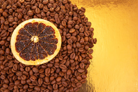 Vibrant dried orange slices contrast with dark coffee beans on a golden reflective surface, a feast for the senses. coffee aroma and taste citrus descriptorsの写真素材