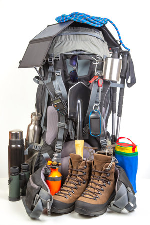 Items for tourism and hiking near a tourist backpack on a white background. set of equipment for tourism and travelの写真素材