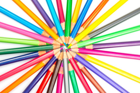 Sharpened colored pencils in a starburst formation on a white backdrop, displaying a rainbow of colors. Ideal for artistic projects, school supplies, or creative design concepts.の写真素材