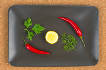 Red hot pepper with lemon on a gray plate. Healthy vegetable food and vitaminsの写真素材