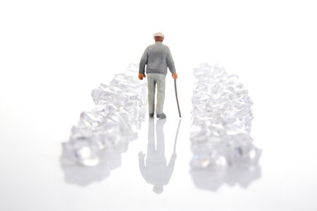 A miniature figure in a gray suit walks through a dazzling crystal-lined path on a reflective surface, representing wealth and progress.の写真素材