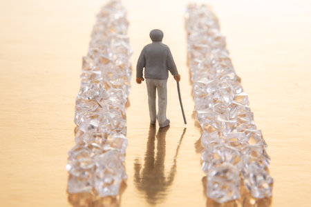 A tiny suited figure walks through a sparkling crystal pathway on a reflective golden base, embodying the pursuit of success and luxury.の写真素材