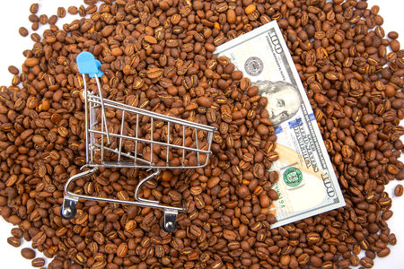 financial concept image featuring a tiny shopping cart, coffee beans, and US currency, symbolizing coffee prices, trade, and economic trendsの写真素材