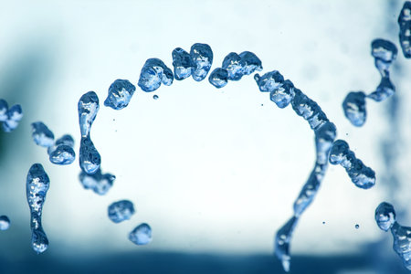 Water droplets suspended in air catching sunlight, forming intricate patterns and reflections. The...