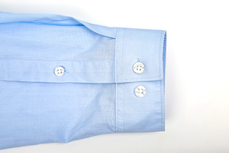 A light blue dress shirt sleeve is displayed, showing two white buttons.