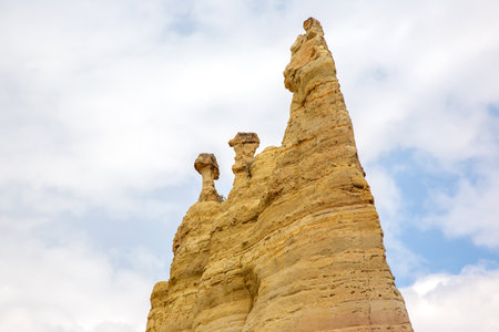 Majestic rock formations rise prominently in Turkey, showcasing their unique shapes against a backdrop of cloudy skies. The natural colors and textures create a stunning visual in the landscape.の写真素材