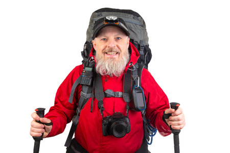 A hiker poses confidently, equipped with a large backpack and essential gear. Dressed in a bright red jacket, he smiles while holding trekking poles, ready for an outdoor exploration.の写真素材