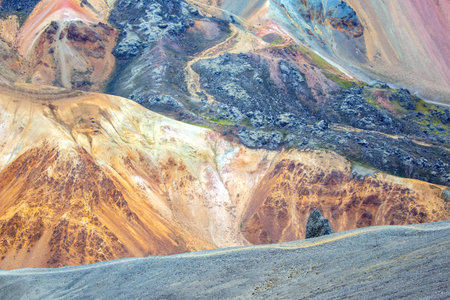 Unique hills showcase vivid colors and textures characteristic of Iceland's landscape, revealing a stunning interplay of mineral deposits and geological formations under soft light.の写真素材