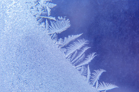 Intricate frost patterns create beautiful designs on a frozen surface, showing nature's artistry...