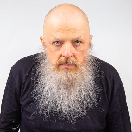 portrait of a man with a large gray beard on a light background.の写真素材
