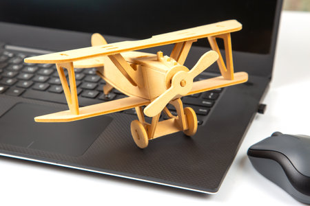 Model of a wooden plane on the background of a laptop.の写真素材