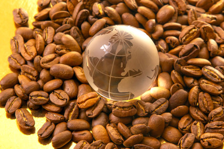 Close-up of roasted coffee beans surrounding a glass globe with world map etchings, highlighting global coffee production. Ideal for beverage and global trade visualsの写真素材