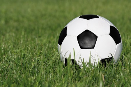 Classic black and white soccer ball on green grassの写真素材