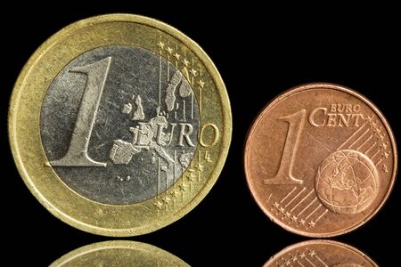 Two used coin - one euro and one eurocent - isolated on black background  Closeup view の写真素材