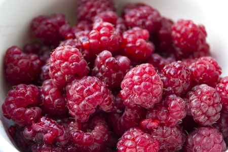 ripe red raspberries in a saucer