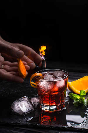 Mezcal Negroni cocktail. Smoky Italian aperitivo. Flamed orange peel.の写真素材