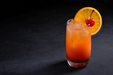 Tequila Sunrise cocktail on dark stone table.の写真素材
