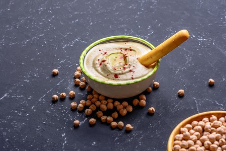 Healthy food. Vegetable sources of protein. Bowl of hummus, on stone table, chickpeas.の写真素材
