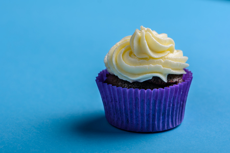 Cupcake in purple wrap on turquoise background.の写真素材