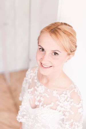 Gorgeous bride with wedding bouquet makeup and hairstyle in bridal dress.の写真素材