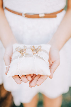 girl holding a pillow for wedding rings
