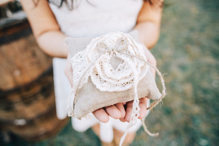 girl holding a pillow for wedding ringsの写真素材