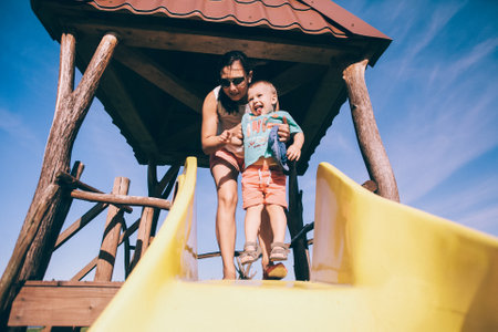 baby with mom on the playgroundの写真素材