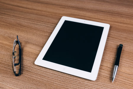 tablet, glasses, and pen on the table, businessの写真素材