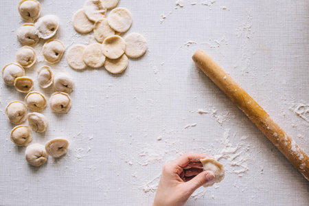 girl makes dumplings at home on the table, close-upの写真素材