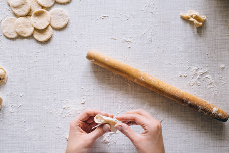 girl makes dumplings at home on the table, close-upの写真素材