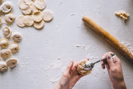 girl makes dumplings at home on the table, close-upの写真素材