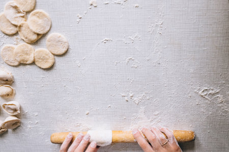 girl makes dumplings at home on the table, close-upの写真素材