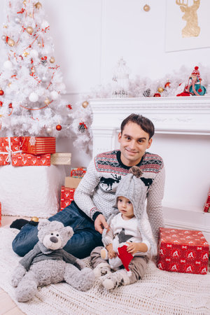 a young father and his son celebrate christmas in a roomの写真素材