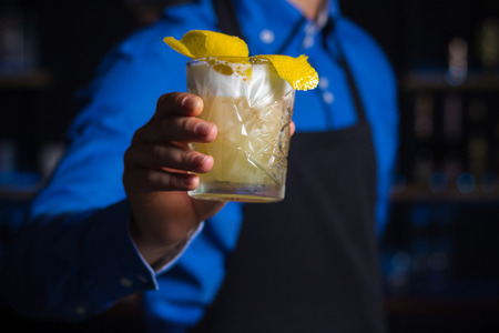 Bartender serves Whiskey sous cocktail in a rox at a bar. Ð¡ocktail card, cocktail menu