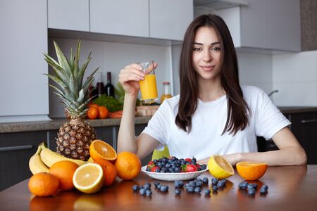 Smiling healthy woman with fresh orange juice in her handsの写真素材