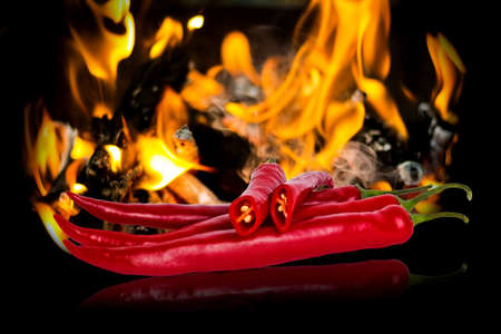 hot red pepper over a flame backgroundの写真素材