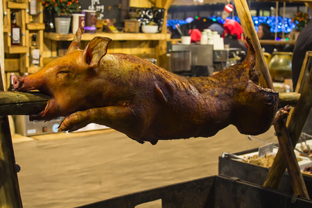 Whole fried parasenok on a spit against the background of the restaurantの写真素材