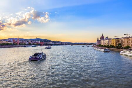 Cruise ships on the Danube River in the evening overlooking the Hungarian Parliament in Budapestの素材 [FY310132213424]