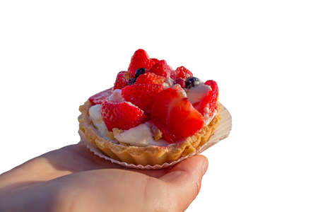 Cake with fruits and berries with cream on hand on a white backgroundの写真素材