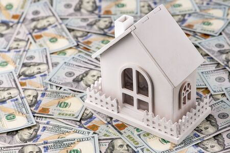 The symbol of the house stands against the background of us dollars