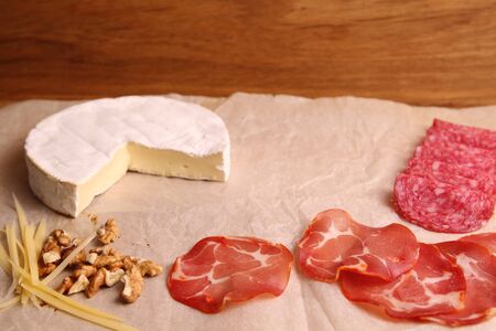 Brie cheese, salami, ham, parmesan and nutsの写真素材