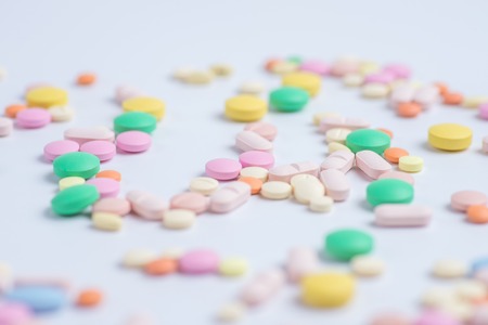 Green and yellow pills or capsules on a white background with copy space.の写真素材