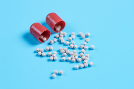Red pills piled pellets on a blue background. Copy space for textの写真素材